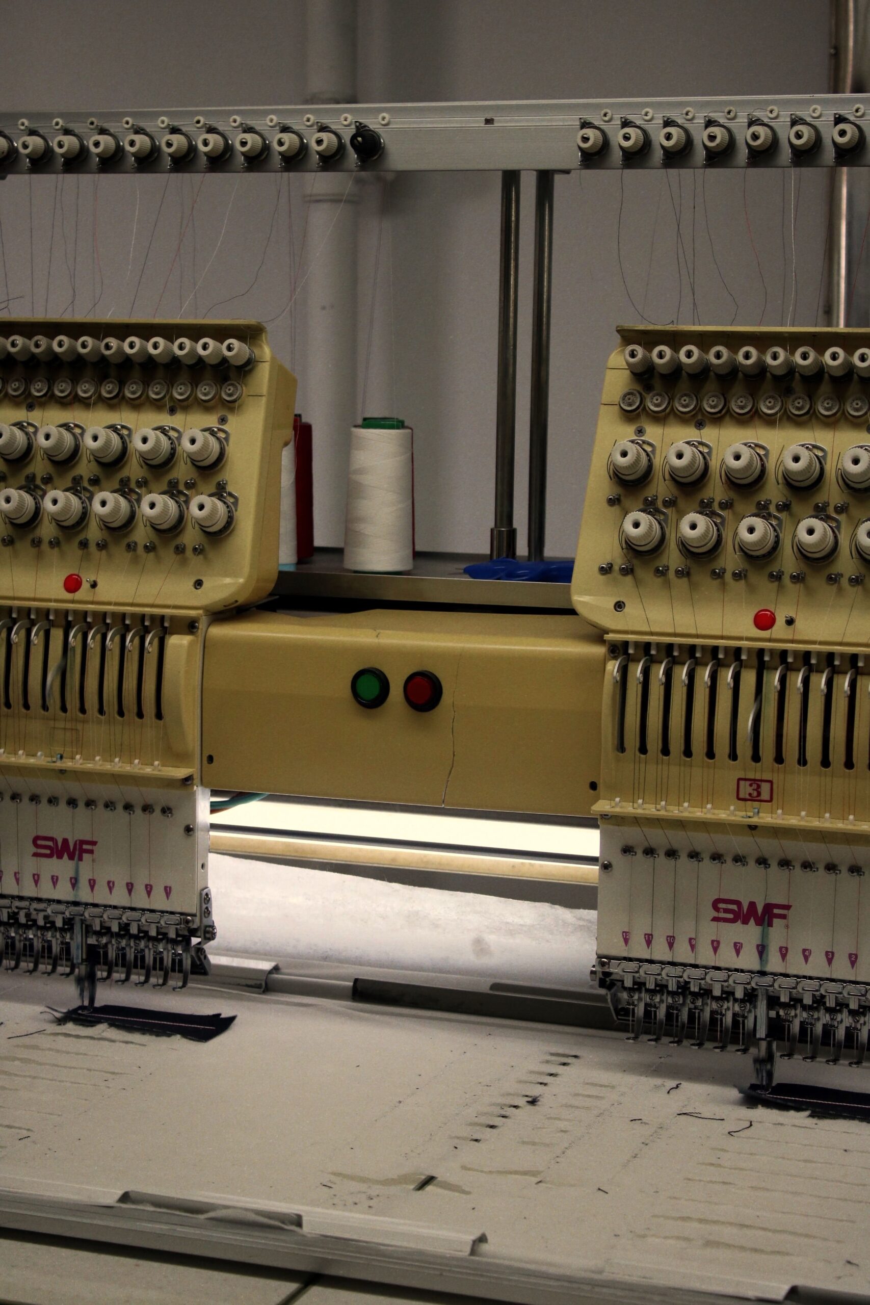 Bordado industrial - Primer plano de máquina bordadora industrial automatizada usada en producción textil en Alemania